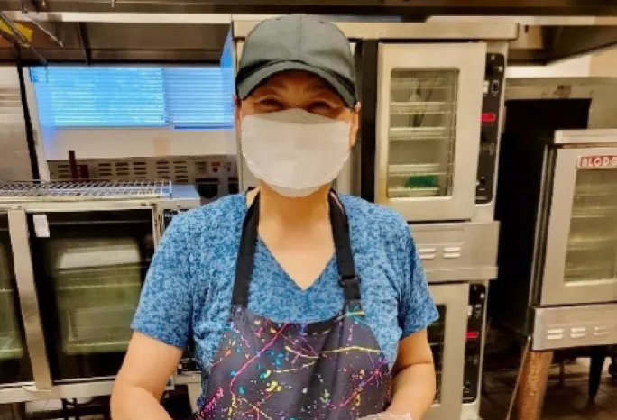 A staff member at MCPS prepares lunch portions