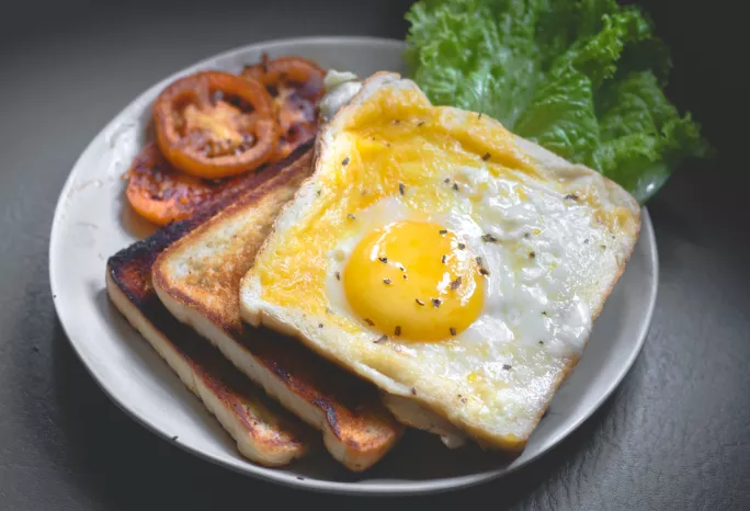 Egg on toast with tomato and lettuce on the side