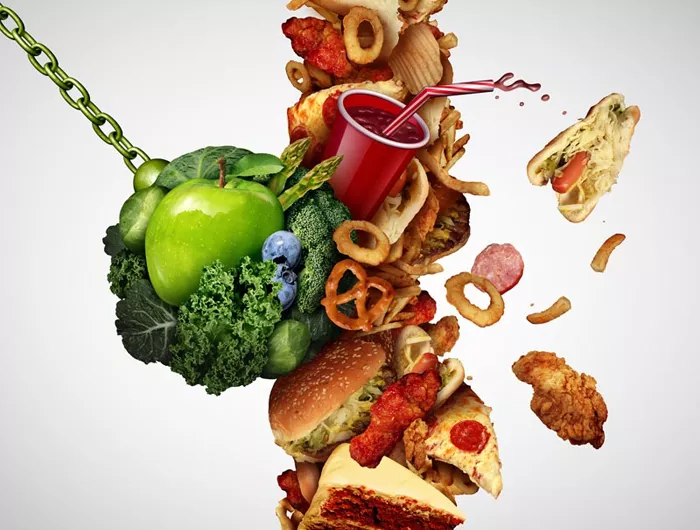 a wrecking ball of produce smashing into unhealthy foods