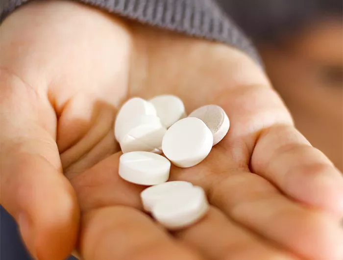 woman holding pills in hand