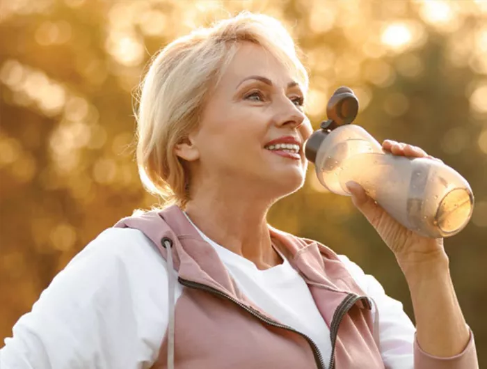 woman drinking out of a sports bottle