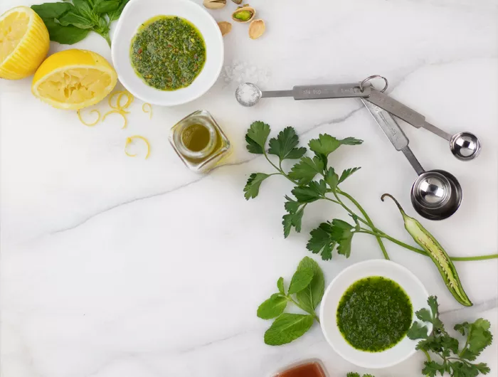 herb sauces with ingredients on marble slab