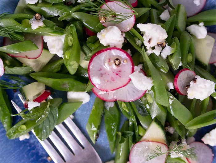 sliced vegetables on a plate with a fork