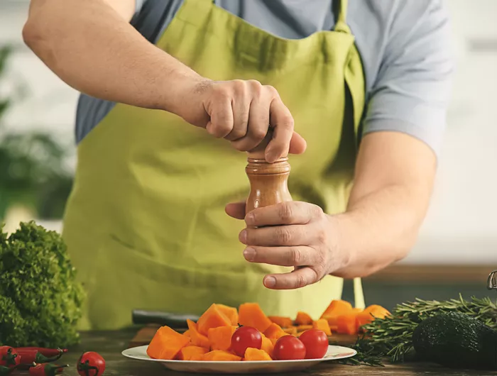 a man seasoning vegetables