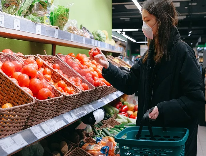 Woman in face mask grocery shopping