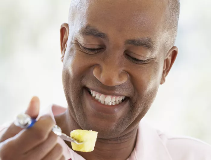 man eating pineapple