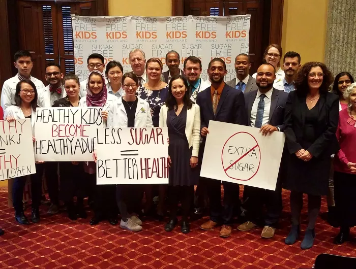 A diverse group holding signs supporting sugar free kids