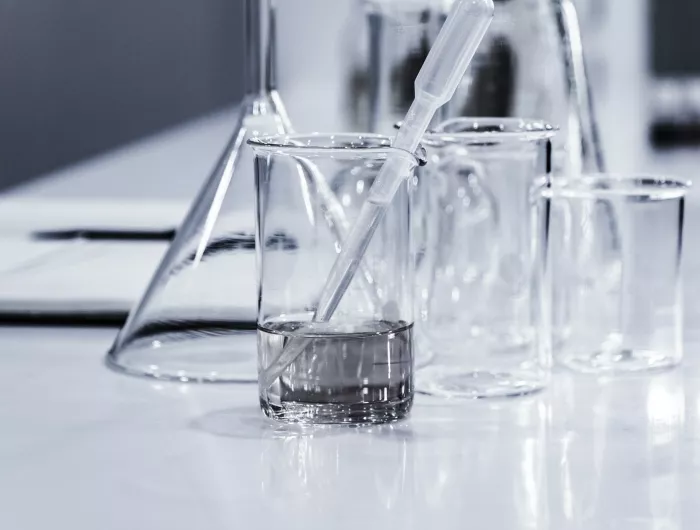 Lab beakers, some containing clear liquid