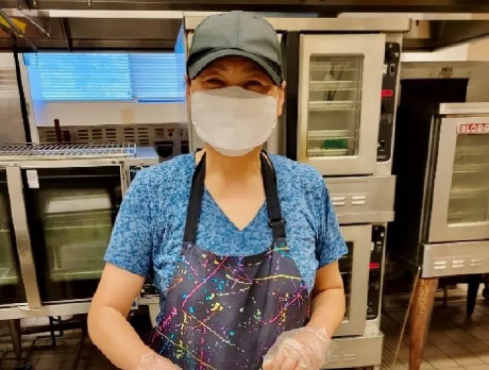 A staff member at MCPS prepares lunch portions