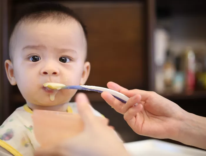 Baby being fed baby food.