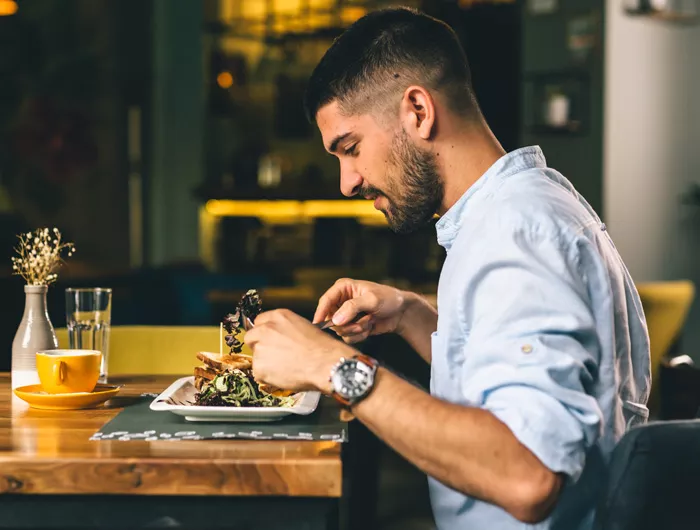 young man sitting and eating a meal