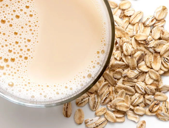 view from above, cup of oat milk with pile of oats next to it 