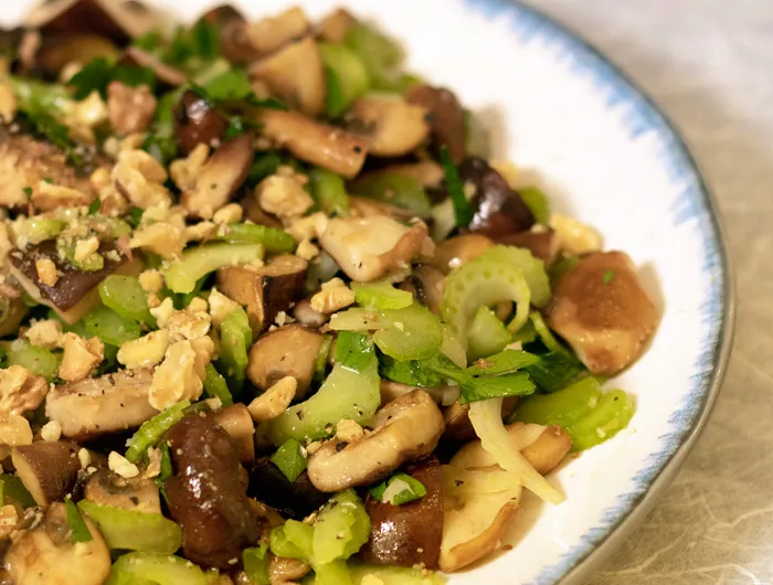 half a plate of crunchy mushroom salad on a white plate