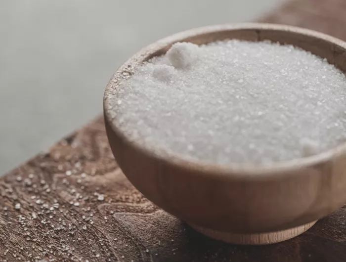 Salt in a wooden bowl on a table