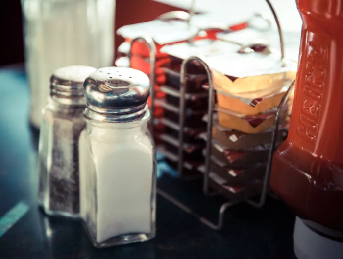 Salt and pepper shakers next to condiments