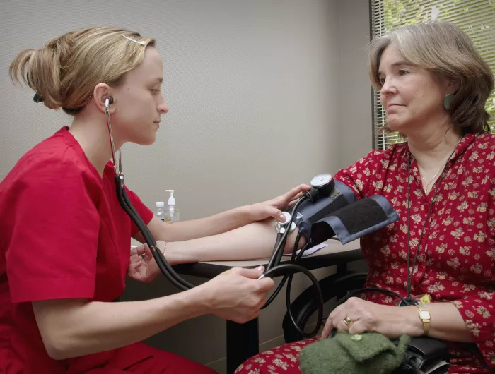 A medical professional taking the blood pressure of her patient.