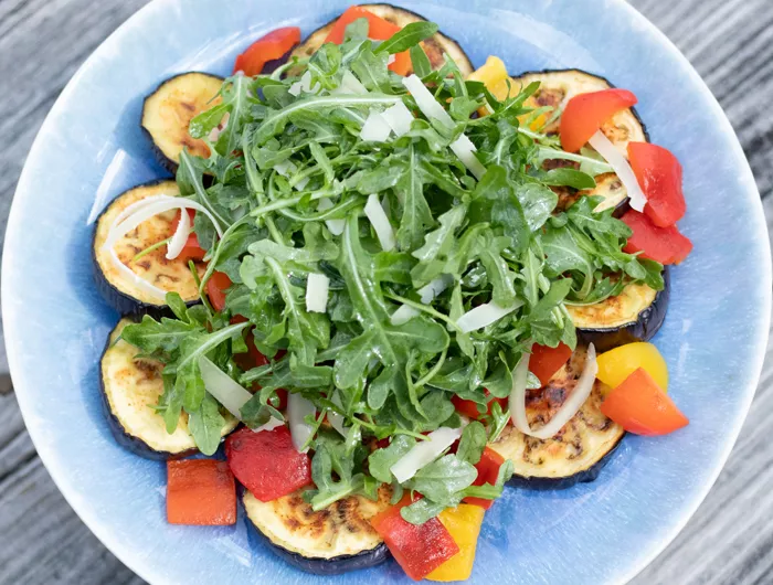 plate with sliced eggplant and arugula