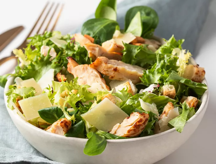 white bowl filled with chicken caesar salad