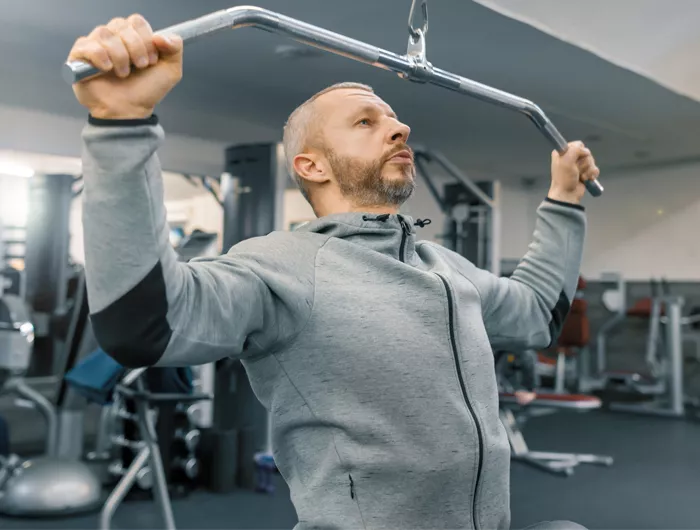 man doing pull ups in a gym