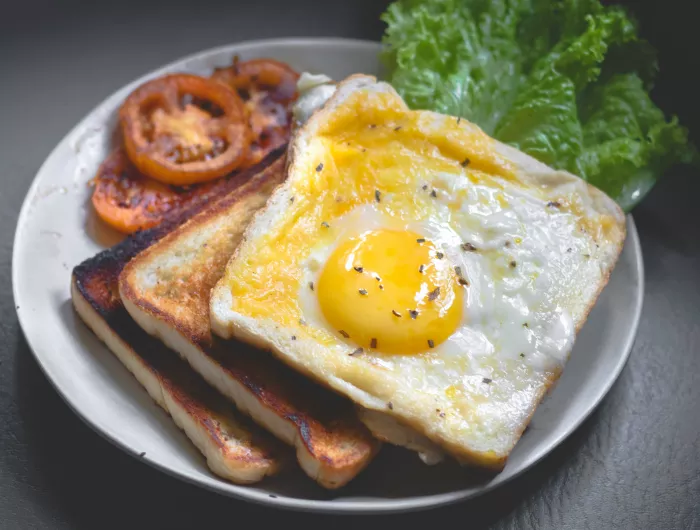 Egg on toast with tomato and lettuce on the side