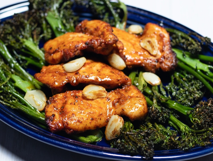 dark blue plate with broccolini and chicken