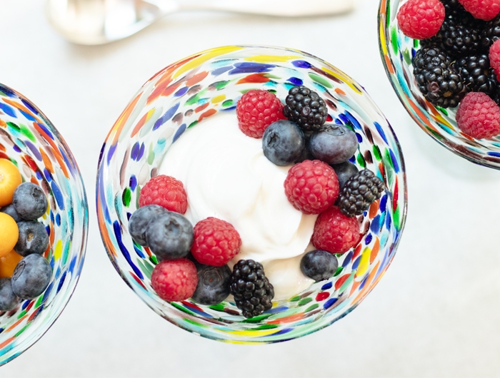 colorful glass bowl holding yogurt and various berries