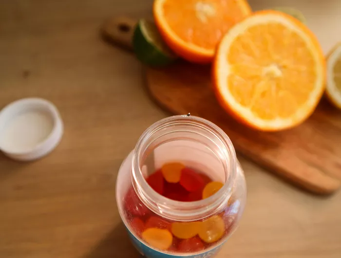 Chewy vitamin C supplements next to a halved orange