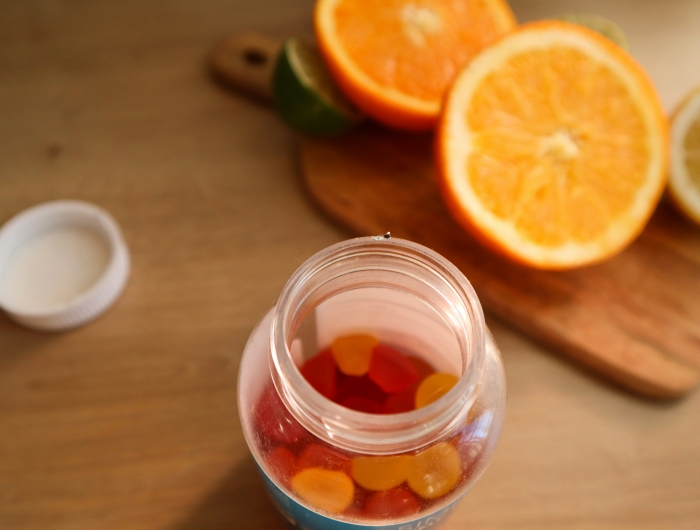 Chewy vitamin C supplements next to a halved orange