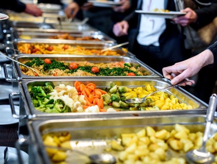 Employees at an office cafeteria choose healthy foods for lunch at work