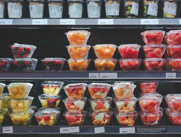 Supermarket shelves containing fruit salad and pre-cut fruits in plastic to go containers