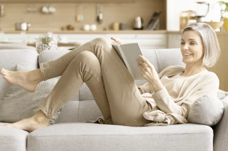 woman lounging and reading on a couch