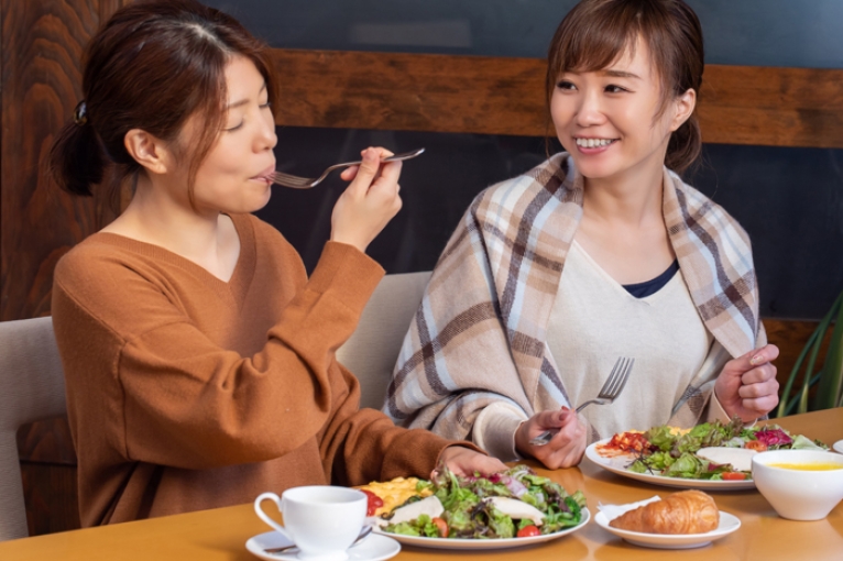 2 women eating salads