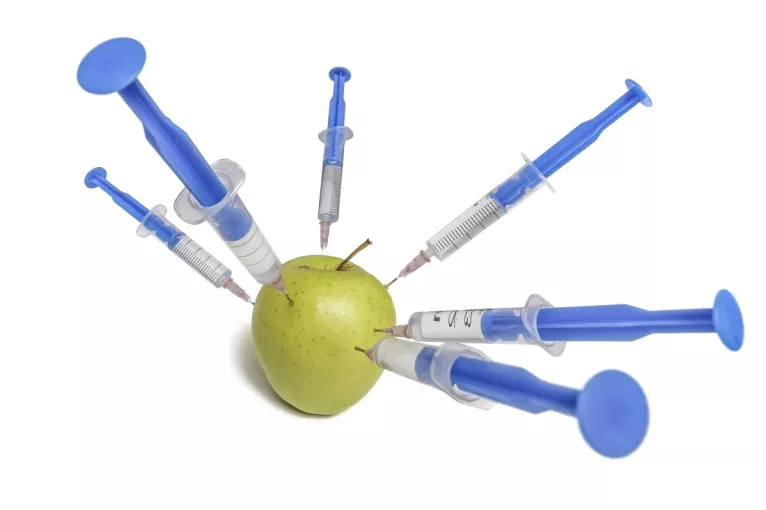 Graphic of an apple being injected by several syringes.