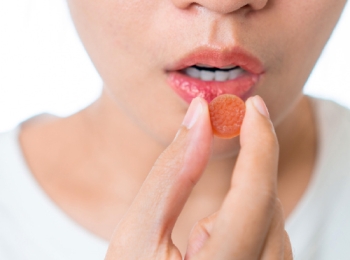 woman eating an orange gummy