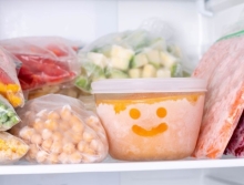 Frozen vegetables in a freezer. A bowl of frozen food with a smiley face drawn in the frost